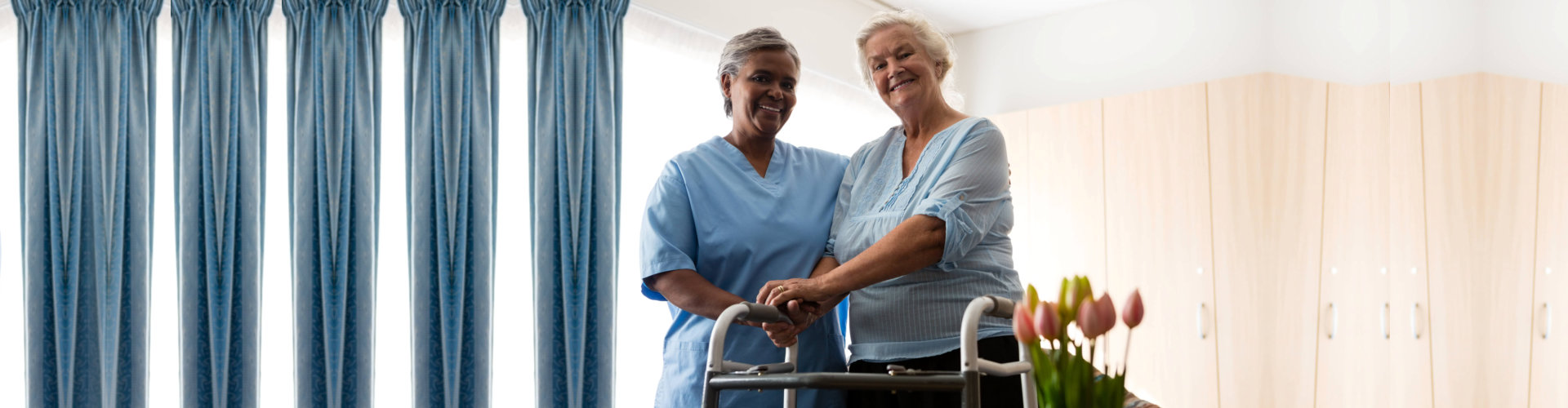 Portrait of nurse standing by senior women holding walker in nursing home